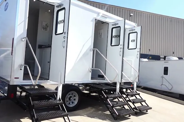 The trailer from its rear corner, with all three doors open and the stairs down