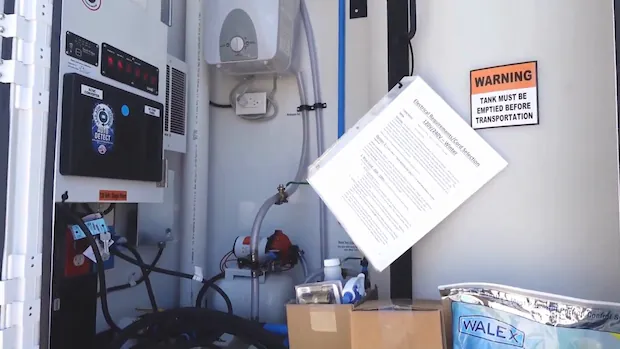 The mechanical room behind its own door, with the tank monitor, the AC/DC converter and the water pump