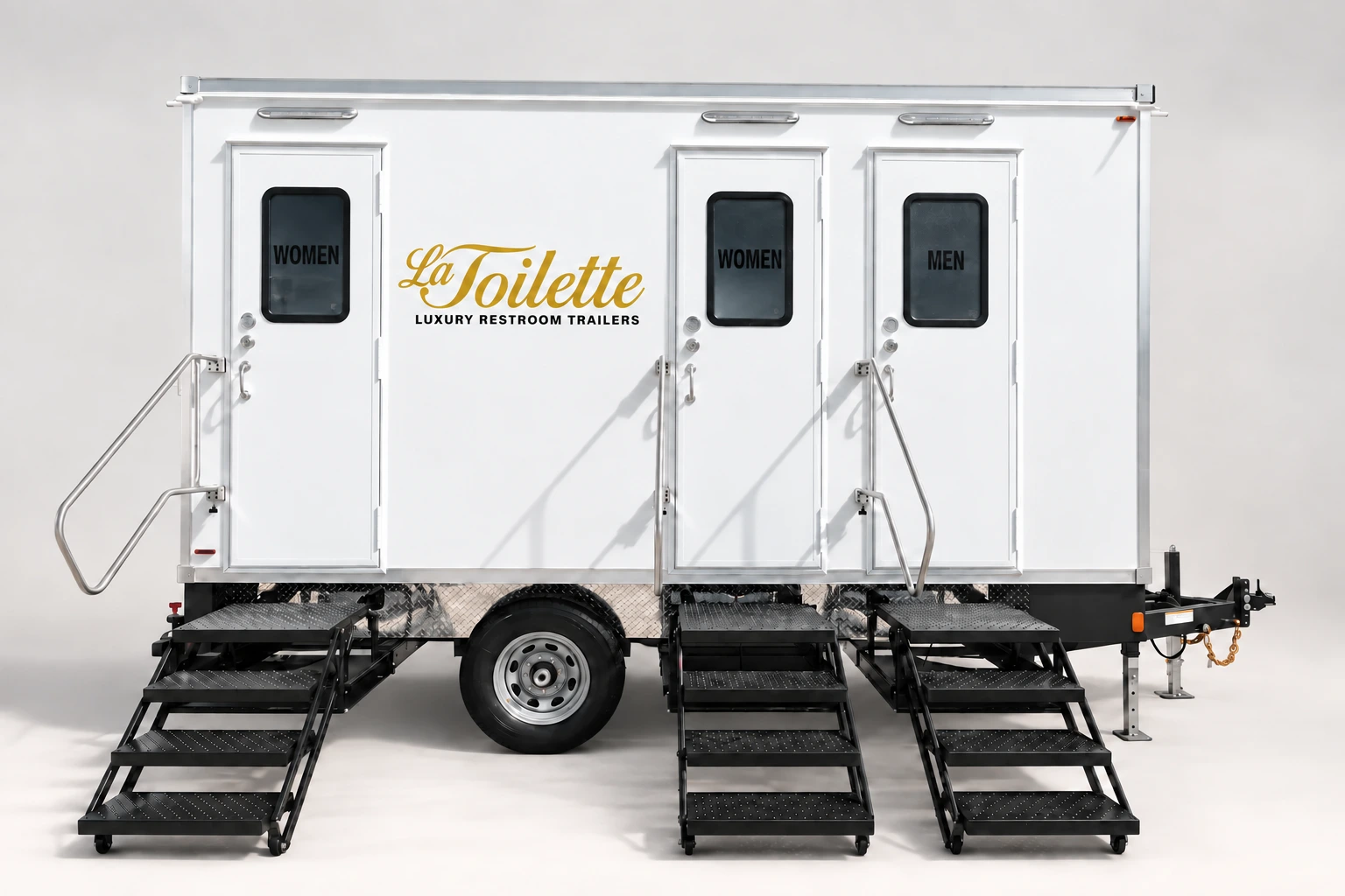 The three-station trailer from the side, doors closed, with the La Toilette wordmark on the flank